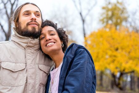 guy with an african american girl in love in autumn park walk at sunsetの写真素材