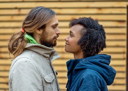 guy with an african  girl in love in autumn park walk at sunsetの写真素材