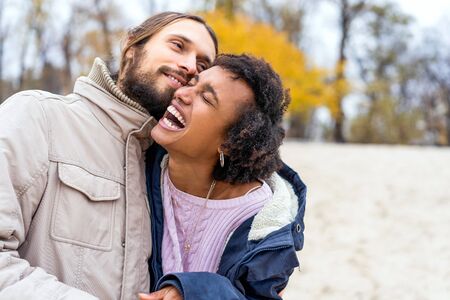 guy with an african american girl in love in autumn park walk at sunsetの写真素材
