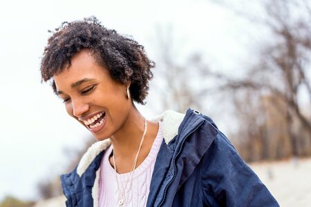 beautiful african girl in autumn park outdoors smiling