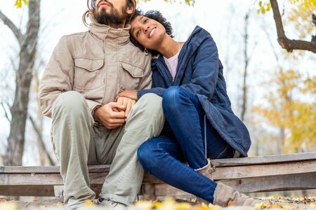guy with an african girl in love in autumn park walk at sunsetの写真素材