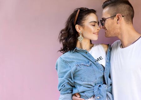 fashion couple in sunglasses posing on pink wallの写真素材