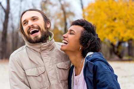 guy with an african american girl in love in autumn park walk at sunsetの写真素材