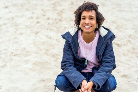 beautiful african girl in autumn park outdoors smilingの写真素材