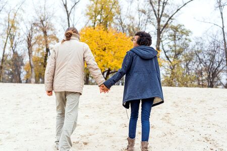 guy with an african american girl in love in autumn park walk at sunsetの写真素材