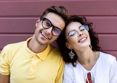 Young fashionable couple on pink backgroundの写真素材