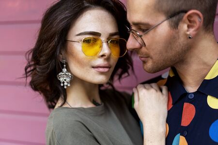 Young fashionable couple on pink backgroundの写真素材