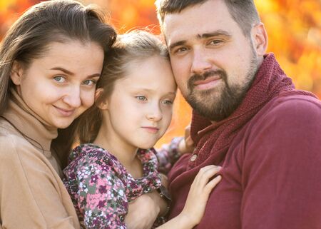 family with daughter walks in autumn parkの写真素材