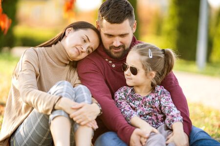 family with daughter walks in autumn parkの写真素材