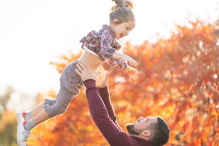 dad with his daughter in the autumn park walksの写真素材
