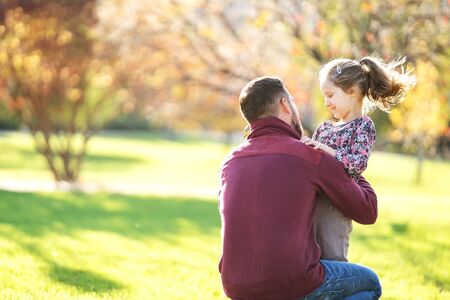 dad and daughter play in the park at sunsetの写真素材