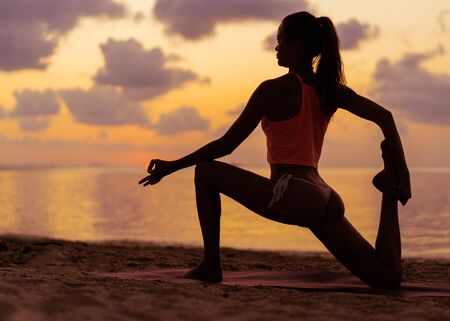 girl doing yoga  and meditation on the mountain at sunsetの写真素材
