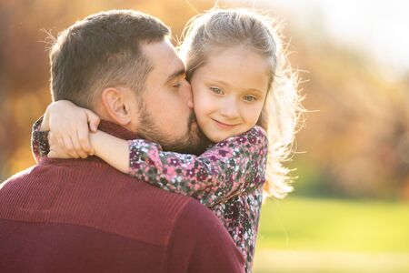 dad and daughter play in the park at sunsetの写真素材