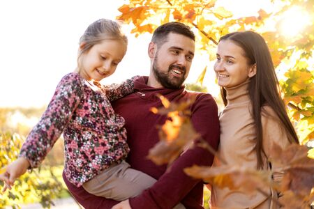family in love play in the autumn park at sunsetの写真素材