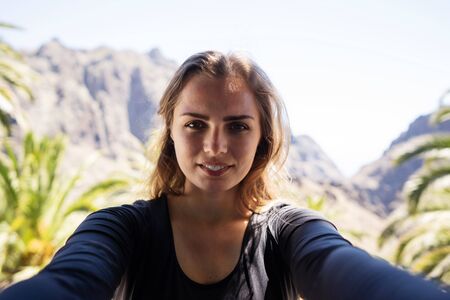 selfie portrait in the mountains on a trip among palm treesの写真素材