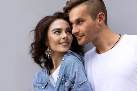 fashion couple posing on a gray background in the streetの写真素材