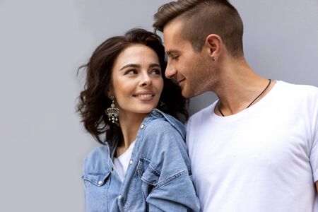 fashion couple posing on a gray background in the streetの写真素材