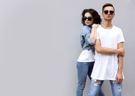 fashion couple posing on a gray background in the streetの写真素材