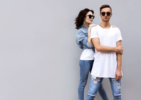 fashion couple posing on a gray background in the streetの写真素材
