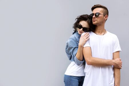 fashion couple posing on a gray background in the streetの写真素材