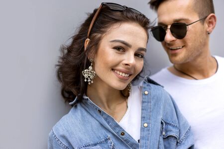 fashion couple posing on a gray background in the streetの写真素材
