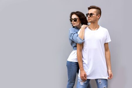 fashion couple posing on a gray background in the streetの写真素材