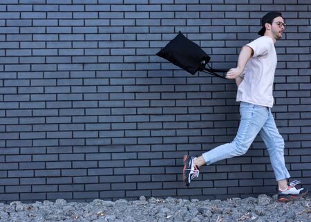 fashion guy posing over brick black urban backgroundの写真素材