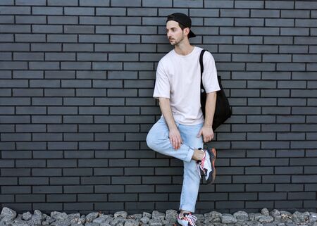 fashion guy posing over brick black urban backgroundの写真素材