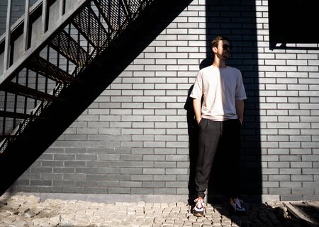 fashion guy posing in sunglasses against a black urban backgroundの写真素材