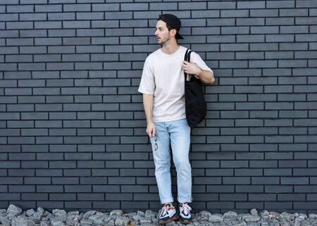 fashion guy posing over brick black urban backgroundの写真素材