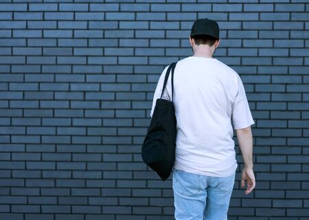 fashion guy posing over brick black urban backgroundの写真素材