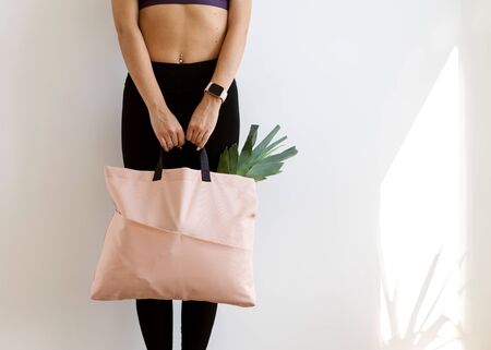 girl with a shopping bag in pink hands with
products. Take away, fitness food.の写真素材