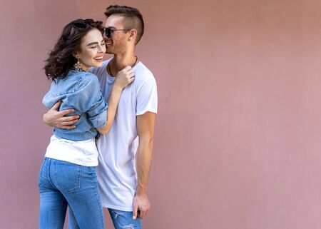 fashion couple in sunglasses posing on pink wallの写真素材