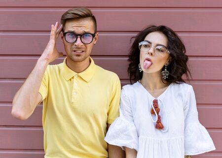Young fashionable couple on pink backgroundの写真素材