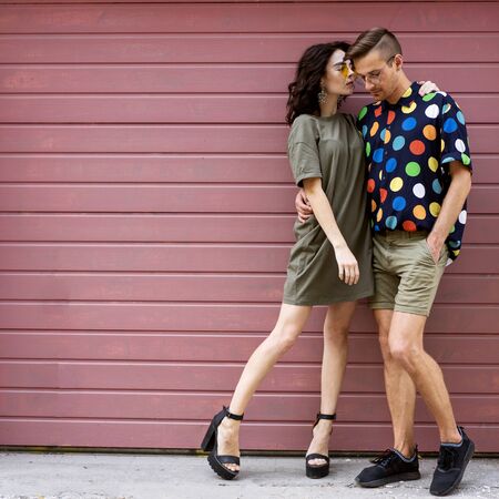 Young fashionable couple on pink backgroundの写真素材