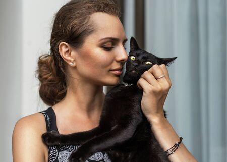 portrait of a beautiful girl with a cat hugsの写真素材