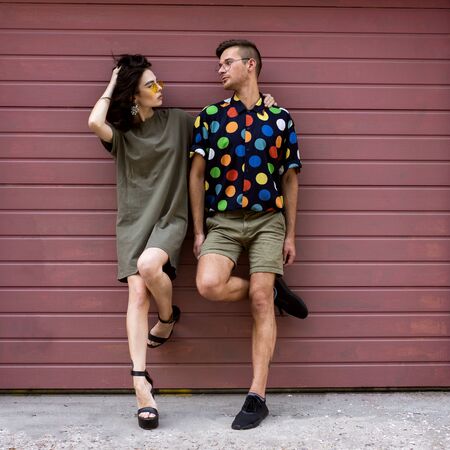 Young fashionable couple on pink backgroundの写真素材