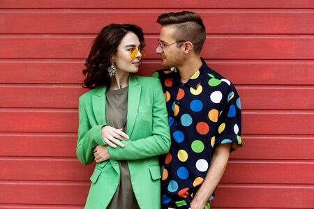 Young fashionable couple on red backgroundの写真素材