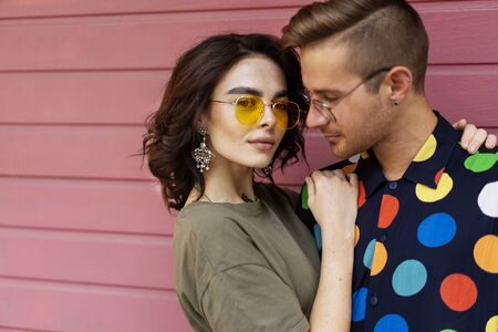 Young fashionable couple on pink backgroundの写真素材