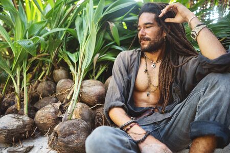 fashion guy with dreadlocks in tropical coconut palms smilingの写真素材