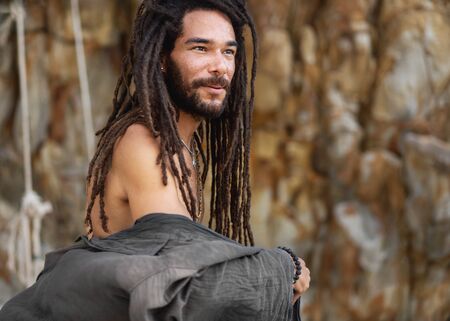 fashion guy with dreadlocks in tropical coconut palms smilingの写真素材