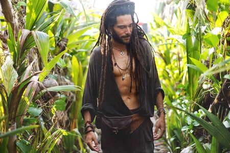 fashion guy with dreadlocks in tropical palm trees smilingの写真素材