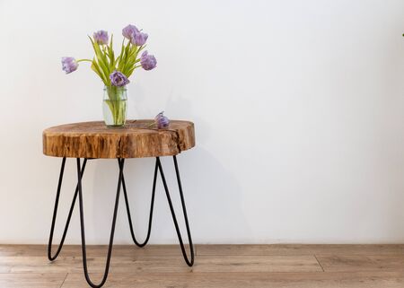 on a beautiful table handmade loft stands a bouquet of tulip flowersの写真素材