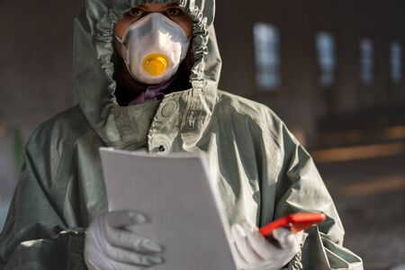 Doctor wearing protection face mask against coronavirus. Staff preventive gear. Holding a poster stay at home in handsの写真素材