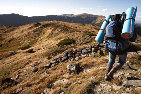 tourist goes to the mountains on a hike at sunsetの写真素材