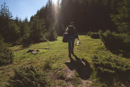 Hiker goes to the mountains on a sunset hike. Ecotourism.の写真素材
