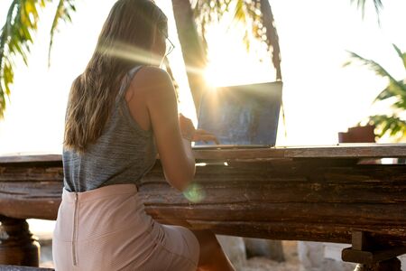freelancer girl sitting working on her veranda by the sea in Thailandの写真素材