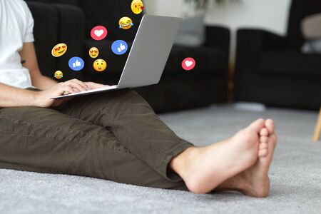 guy watching a social media live stream on a computer at homeの写真素材