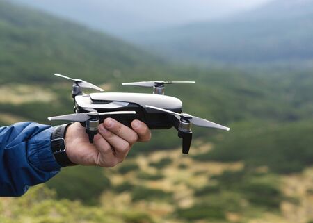guy tourist holding a drone in the mountainsの写真素材