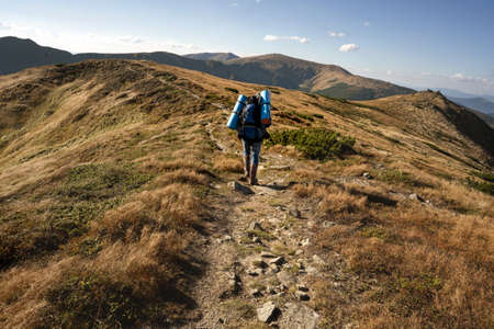 Hikers goes to the mountains on a sunset hike. Ecotourism.